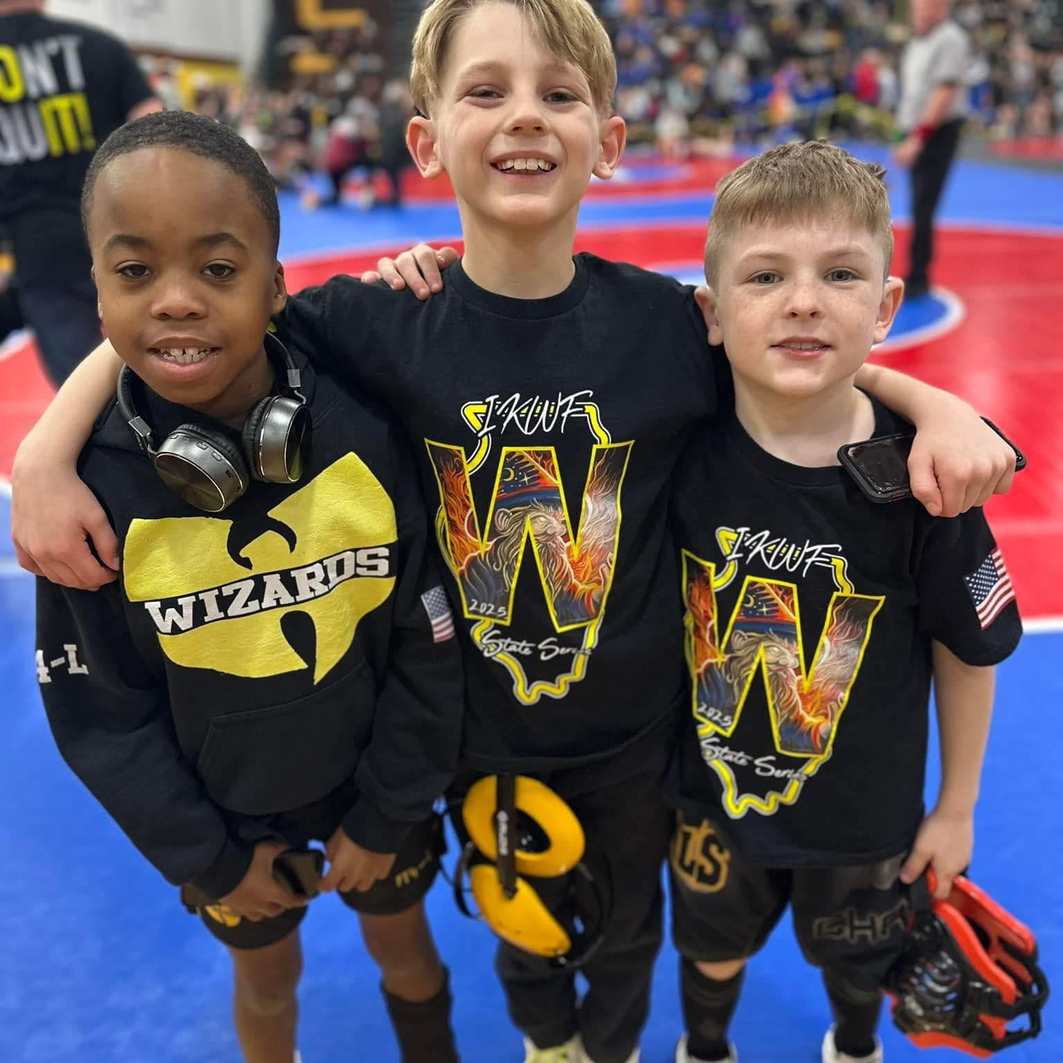 Three young Wizards wrestlers in club gear at an IKWF state-series tournament